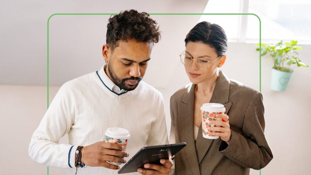 Zwei Lernende, die auf einem Tablet ihr LMS betrachten, auf dem ihr Lernfortschritt angezeigt wird – Synergy Learning