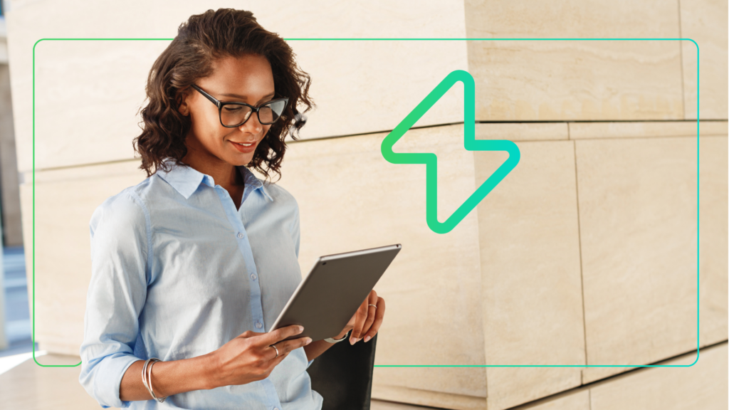 Eine Frau, die zufrieden das LMS-Dashboard auf ihrem Tablet betrachtet, mit dem „ Spark  “-Theme unterSynergy Learning
